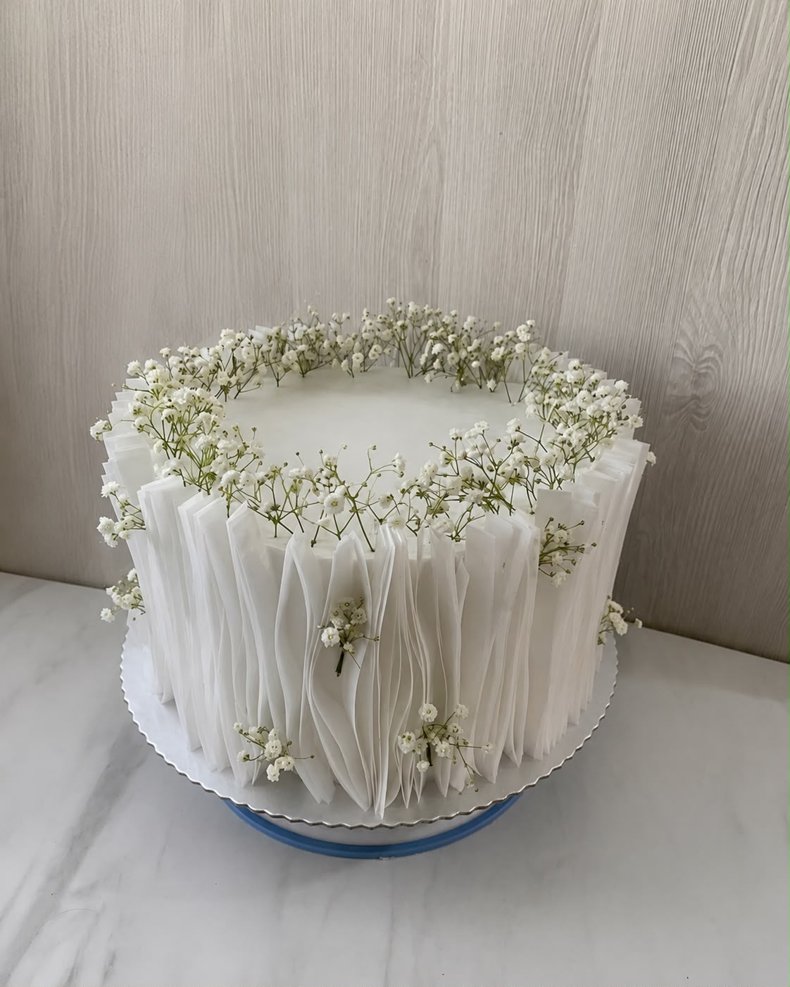 Bijela teksturirana torta sa sitnim cvijećem.