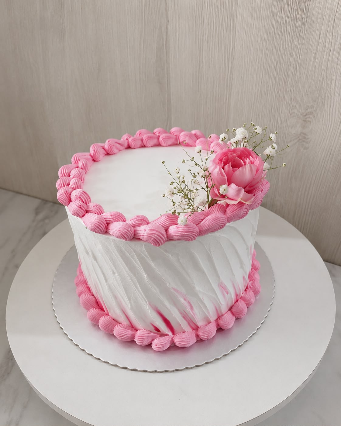 Bijelo-roza svečana torta sa cvijetom.